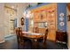 Warm dining room showcases a wooden table set beneath a chandelier, with a wall of built-in cabinets at 5155 W Quincy Ave # 101, Denver, CO 80236