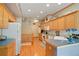 Functional kitchen with hardwood floors, wooden cabinetry, and ample counter space at 5155 W Quincy Ave # 101, Denver, CO 80236