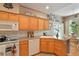 Bright kitchen with wooden cabinets, white appliances, and a cozy dining area at 5155 W Quincy Ave # 101, Denver, CO 80236
