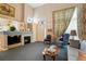 Comfortable living room with a fireplace, ample seating, and a tall ceiling at 5155 W Quincy Ave # 101, Denver, CO 80236