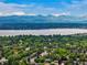 Scenic aerial view of a peaceful neighborhood, lake and mountain backdrop at 5155 W Quincy Ave # 101, Denver, CO 80236