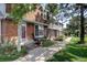 Charming brick townhome with landscaped front yard and inviting entryway, showcasing curb appeal at 7396 S Knolls Way, Centennial, CO 80122