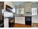 Modern kitchen with white cabinets, black appliances, and stylish backsplash at 7396 S Knolls Way, Centennial, CO 80122