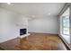Bright living room featuring wood floors, a fireplace, and a large window for natural light at 7396 S Knolls Way, Centennial, CO 80122