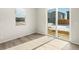 A bright bedroom features wood-look floors and a sliding glass door to the backyard at 6068 Corral St, Brighton, CO 80601