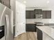 This kitchen features gray cabinets, stainless steel appliances, granite counters, and wood-look flooring at 6068 Corral St, Brighton, CO 80601