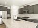 Modern kitchen featuring stainless steel appliances, grey cabinetry, mosaic backsplash, and a spacious island with granite countertop at 6068 Corral St, Brighton, CO 80601
