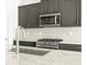 This kitchen features gray cabinets, granite counters, and stainless steel appliances at 6068 Corral St, Brighton, CO 80601