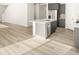 This open-concept kitchen features gray cabinets, stainless steel appliances, granite counters, and wood-look flooring at 6068 Corral St, Brighton, CO 80601