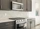 This kitchen features gray cabinets, granite counters, stainless steel appliances, and a subway tile backsplash at 6068 Corral St, Brighton, CO 80601