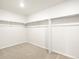 Spacious walk-in closet showcasing a carpeted floor and white walls with open storage solutions at 6068 Corral St, Brighton, CO 80601