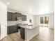 Modern kitchen featuring stainless steel appliances, gray cabinets, and a large island with granite countertops at 6068 Corral St, Brighton, CO 80601