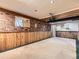Spacious basement featuring brick accent wall, wood paneling, and a carpeted floor at 1076 S Leyden St, Denver, CO 80224
