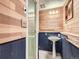 Bathroom featuring wood plank walls, pedestal sink, and glass-enclosed shower at 1076 S Leyden St, Denver, CO 80224