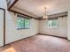 Bedroom with two windows, neutral walls, wood trim, chandelier, and light brown carpet at 1076 S Leyden St, Denver, CO 80224