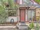 Close-up of the home's front entrance with a red door, pergola, and wooden bench at 1076 S Leyden St, Denver, CO 80224