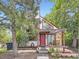 Unique home exterior featuring a red door, pergola, and mature landscaping at 1076 S Leyden St, Denver, CO 80224