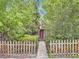 Home's exterior partially hidden by trees, showing a fenced-in yard at 1076 S Leyden St, Denver, CO 80224