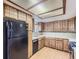 Traditional kitchen featuring wooden cabinets, laminate countertops, tile backsplash, and modern appliances at 1076 S Leyden St, Denver, CO 80224