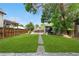 Expansive backyard with a lush lawn, mature trees, and a concrete pad in the back at 3254 Newton St, Denver, CO 80211