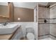 Tiled bathroom with a modern sink, toilet, and a tiled shower with a black shower head fixture at 3254 Newton St, Denver, CO 80211