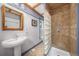 A cozy bathroom showcasing a sink, and a glass block shower, with a unique design at 3254 Newton St, Denver, CO 80211