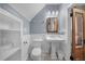 Updated bathroom featuring tiled floors, a pedestal sink, and a vintage-style toilet at 3254 Newton St, Denver, CO 80211