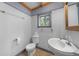 This bathroom features a toilet and sink, adorned with stylish wainscoting and charming trim at 3254 Newton St, Denver, CO 80211