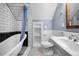 Bright bathroom with a black and white tile floor, a clawfoot bathtub, and an alcove with built in shelving at 3254 Newton St, Denver, CO 80211