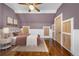 This bedroom features hardwood floors, a ceiling fan, and a unique purple accent wall at 3254 Newton St, Denver, CO 80211