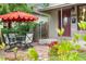 Cozy front porch with a red umbrella, outdoor seating, brick paving and well-maintained flowers at 3254 Newton St, Denver, CO 80211