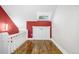 Upstairs hallway space featuring hardwood floors, a skylight, and bright red accent wall at 3254 Newton St, Denver, CO 80211