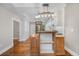 Open concept kitchen with hardwood floors, butcher block island, white cabinets, and stainless steel appliances at 3254 Newton St, Denver, CO 80211