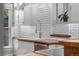 Close up of kitchen with stainless steel faucet, white subway tile, wood countertops, and potted plant at 3254 Newton St, Denver, CO 80211