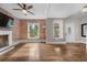 Bright living room features hardwood floors, exposed brick wall, and large windows offering natural light at 3254 Newton St, Denver, CO 80211