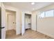 Light-filled bedroom with wood floors and an open closet with built-in drawers and shelving at 4350 S Delaware St, Englewood, CO 80110