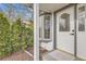 Close-up of a stylish front door with decorative glass, accompanied by lush greenery and a bay window at 4350 S Delaware St, Englewood, CO 80110