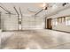 Spacious garage with two white doors, concrete floor, and windows at the far end for natural light at 4350 S Delaware St, Englewood, CO 80110
