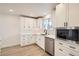 Well-lit kitchen featuring white cabinets, stainless steel appliances, and elegant countertop space at 4350 S Delaware St, Englewood, CO 80110