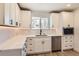 Bright kitchen with white cabinetry, modern appliances, and a window providing natural light at 4350 S Delaware St, Englewood, CO 80110