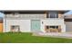 Inviting two-story home with a painted brick facade and a bright teal-colored front door at 6163 W 76Th Ave, Arvada, CO 80003
