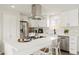 Bright and airy kitchen boasts stainless steel appliances, an island with seating and clean white cabinetry at 6163 W 76Th Ave, Arvada, CO 80003