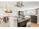 Open floor plan kitchen features an island with modern stainless steel appliances and breakfast bar seating at 6163 W 76Th Ave, Arvada, CO 80003