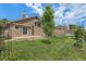 Back exterior showcasing the large grassy lawn, patio, and fenced perimeter at 10152 Telluride St, Littleton, CO 80125