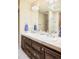 Bathroom featuring a double vanity, framed mirror, neutral colors, and modern fixtures at 2253 Augusta Dr, Evergreen, CO 80439