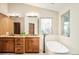 Modern bathroom featuring wooden cabinets, granite countertops, soaker tub and tile walls at 2253 Augusta Dr, Evergreen, CO 80439