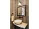 Stylish powder room featuring unique stone vessel sink, leopard print wallpaper, and black fixture accents at 2253 Augusta Dr, Evergreen, CO 80439