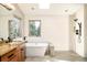 Bright bathroom with a soaking tub, granite vanity, and tiled shower at 2253 Augusta Dr, Evergreen, CO 80439