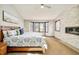 Serene bedroom with stone accent wall, fireplace, large bay window, and neutral carpet at 2253 Augusta Dr, Evergreen, CO 80439