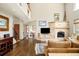 Living area with hardwood floors, a stone fireplace, and natural light from large windows at 2253 Augusta Dr, Evergreen, CO 80439